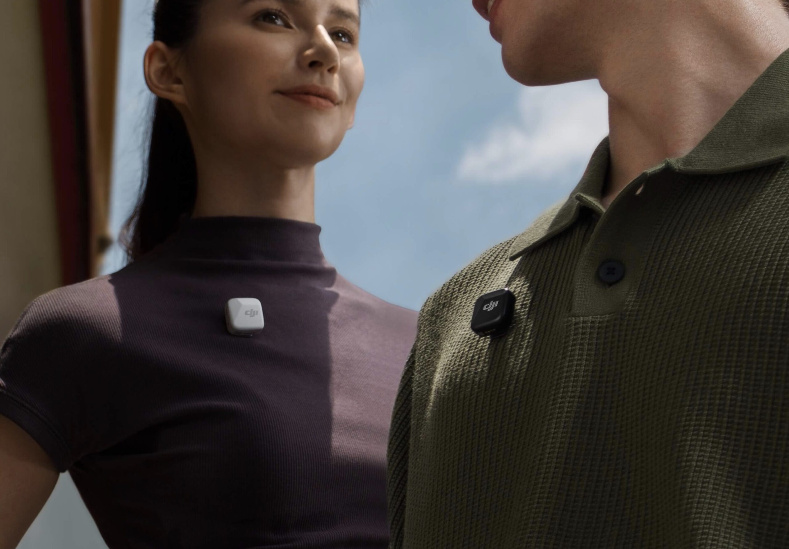 Two people facing each other, both are wearing Mic Mini, one white one black. 