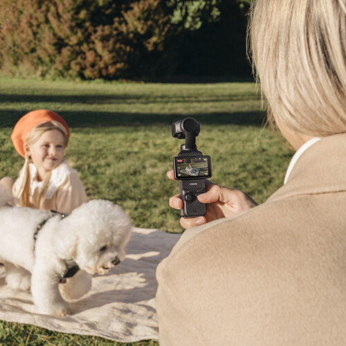 Imagin of a person using DJI Osmo Pocket 3 to capture a kid and a puppy