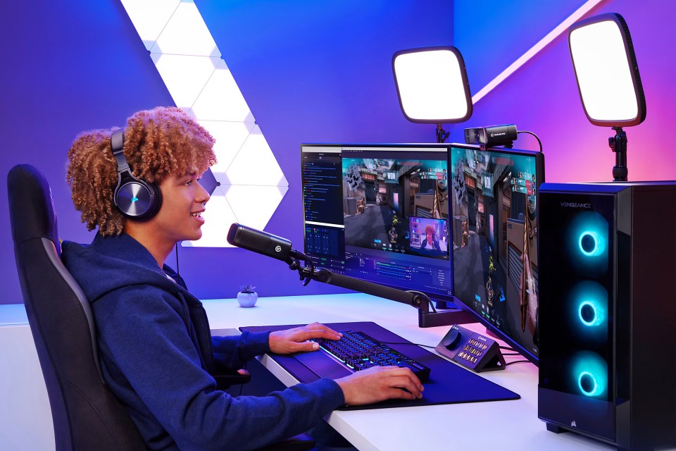 Streamer using dual monitors, microphone, and Elgato Facecam Pro in a gaming setup with studio lighting