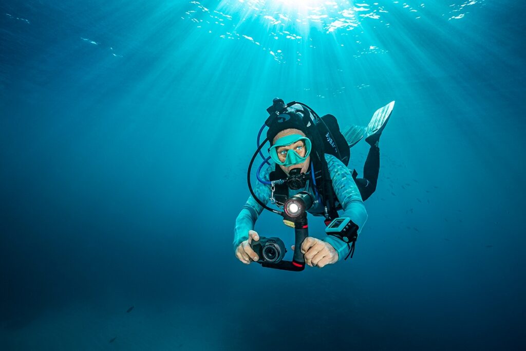 A photograph of a deep-sea diver holding a camera taken from sealife-cameras.com.