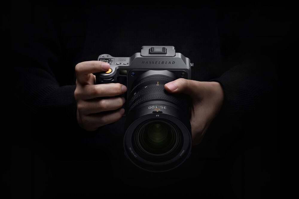 Hasselblad X2D II 100C being held against a black background.