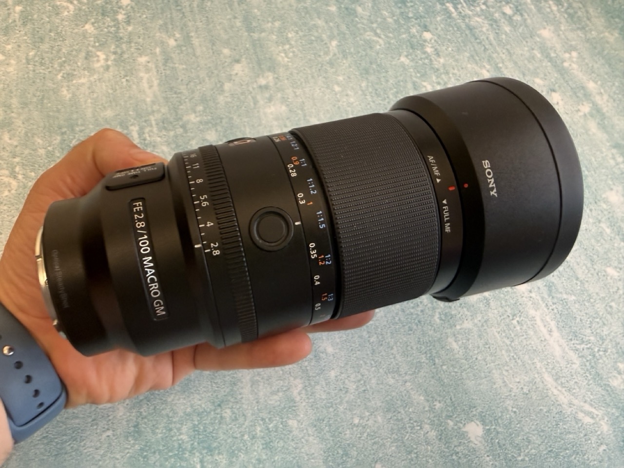 Sony 100mm macro on a blue table with white background