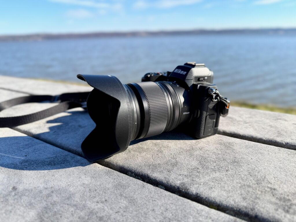 Nikon Z5 II with the nikon-dx-16-50mm-f-2-8-v on a bench by a river.